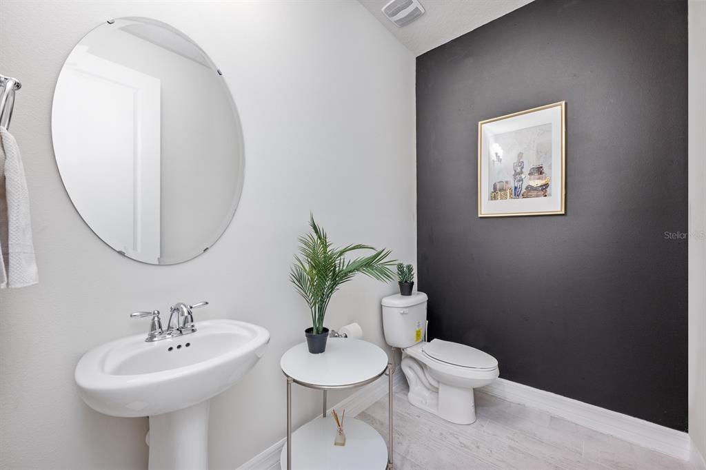 2713 Hilltop Loop Apopka, FL 32712 - Photo 30 of 54 a bathroom with a toilet a sink and a mirror