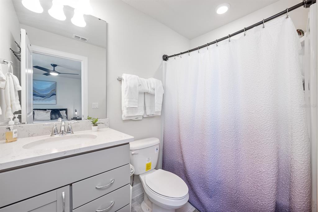 2713 Hilltop Loop Apopka, FL 32712 - Photo 33 of 54 a bathroom with a sink a toilet a mirror and shower curtain