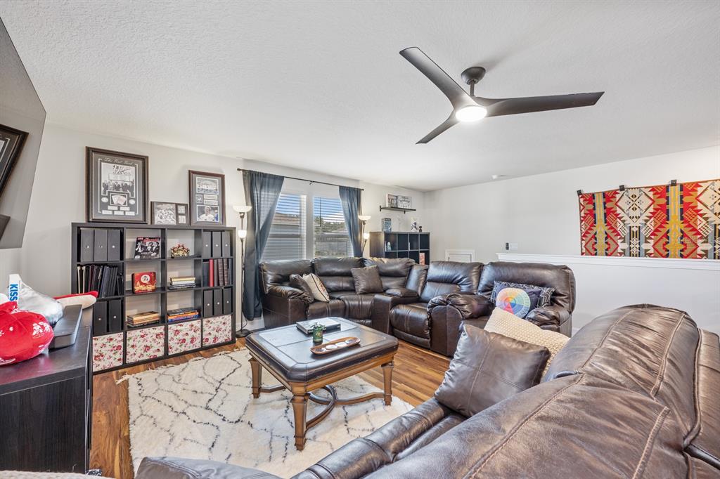 2713 Hilltop Loop Apopka, FL 32712 - Photo 41 of 54 a living room with furniture a rug and a bookshelf