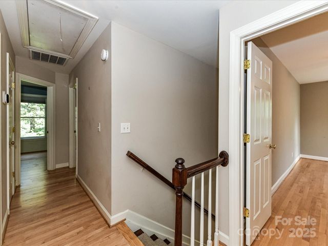 a view of a hallway with wooden floor and staircase