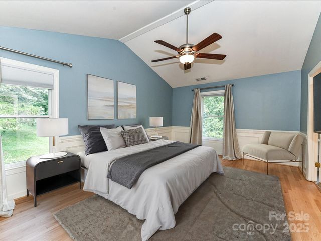 a bedroom with a bed couches and window