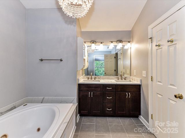 a bathroom with a tub sink and mirror