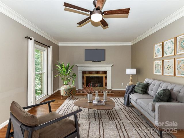 a living room with furniture a fireplace and a floor to ceiling window