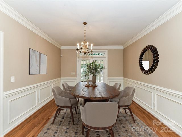 a dining room with furniture a potted plant and wooden floor