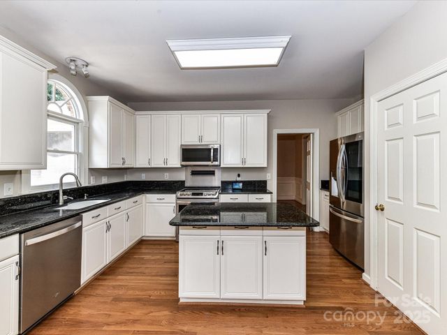 a kitchen with stainless steel appliances a stove sink and refrigerator