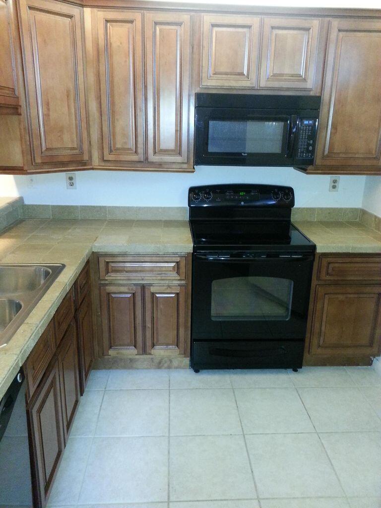 a kitchen with granite countertop a stove top oven and cabinets