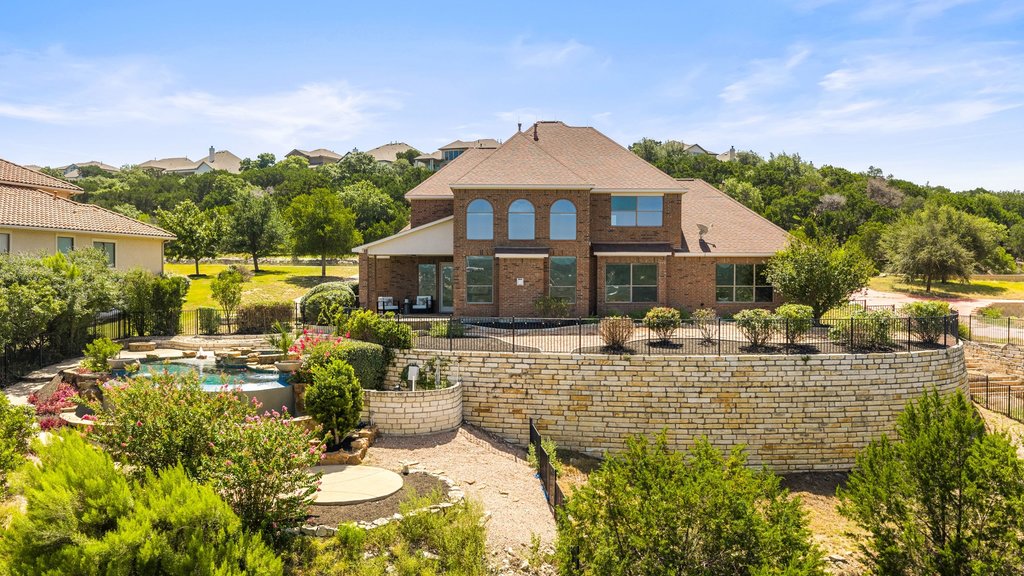 2702 Lakehurst Road Spicewood, TX 78669 - Photo 39 of 40 A tiered backyard retreat offers a glistening pool, extensive landscaping, and scenic views from the upper patio.