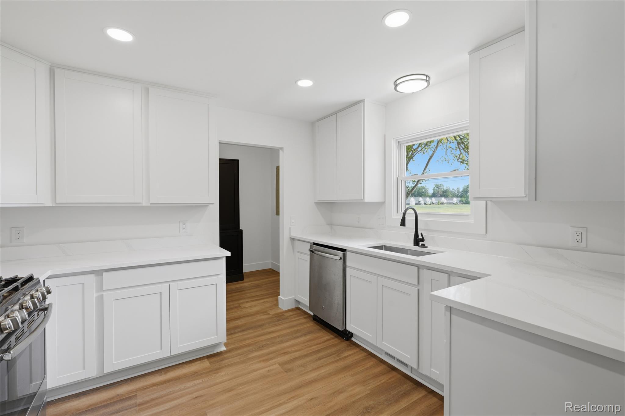 4655 Denton Road Canton, MI 48188 - Photo 16 of 54 White shaker-style cabinetry, stainless steel dishwasher, wood-finish flooring, white countertops, and recessed lighting