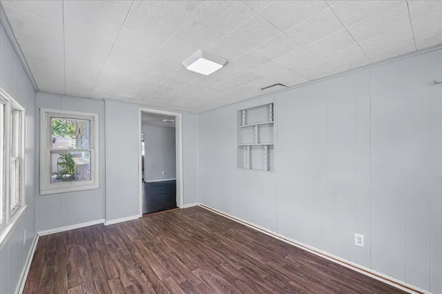 wooden floor in an empty room with a window
