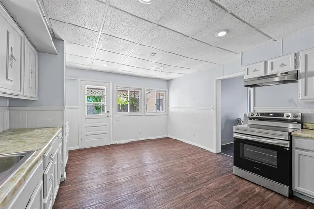 a kitchen with a stove wooden floor and a window