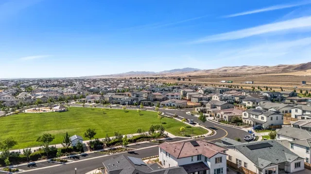 an aerial view of a city with lots of residential buildings and mountain view in back