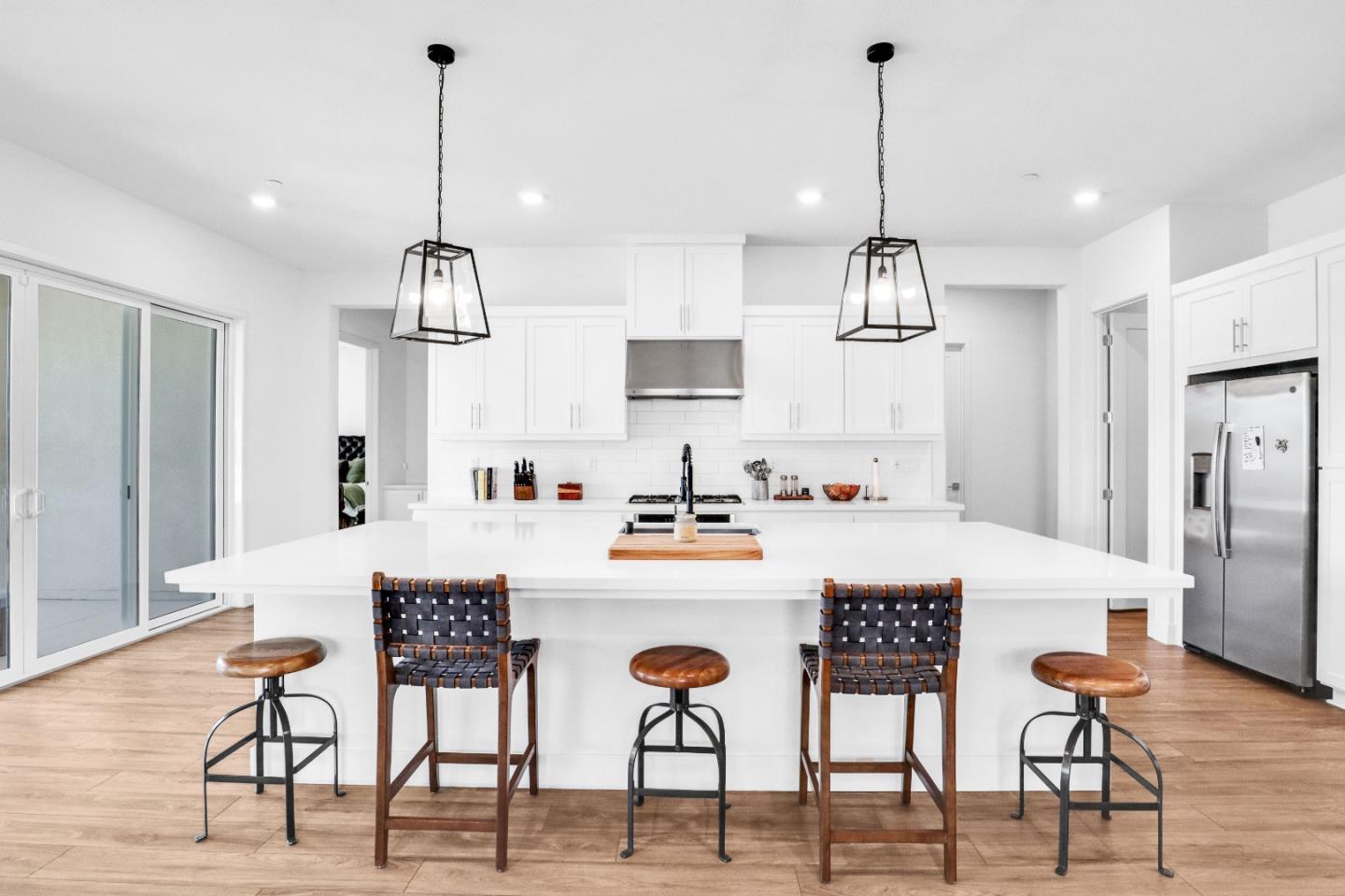 6326 Moser Way Tracy, CA 95377 - Photo 7 of 45 a kitchen with stainless steel appliances kitchen island granite countertop a table chairs and a refrigerator