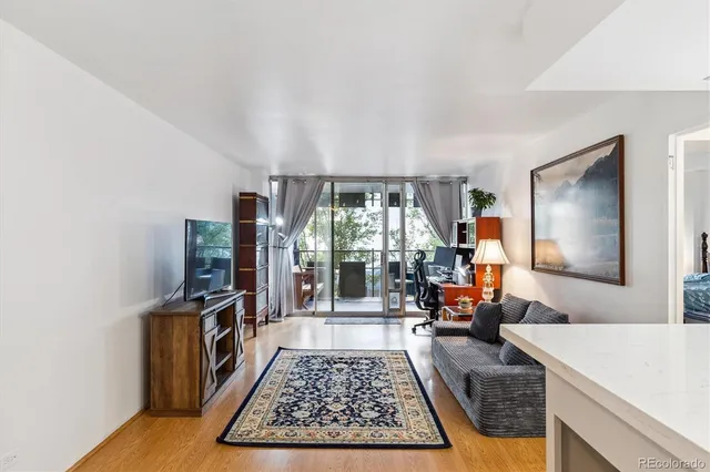 a living room with furniture flat screen tv and a large window