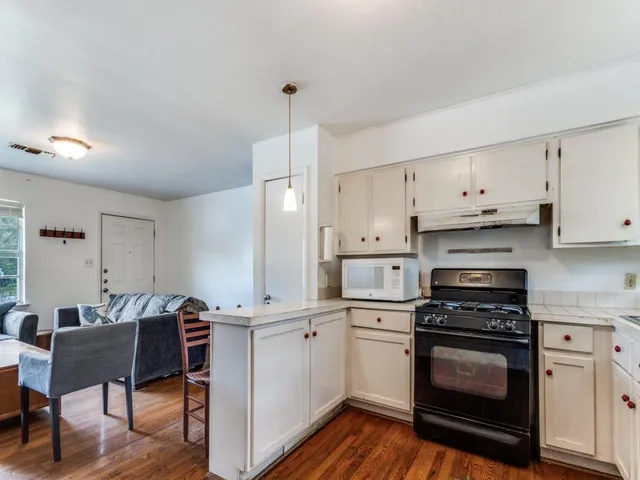 a kitchen with cabinets wooden floor and a sink
