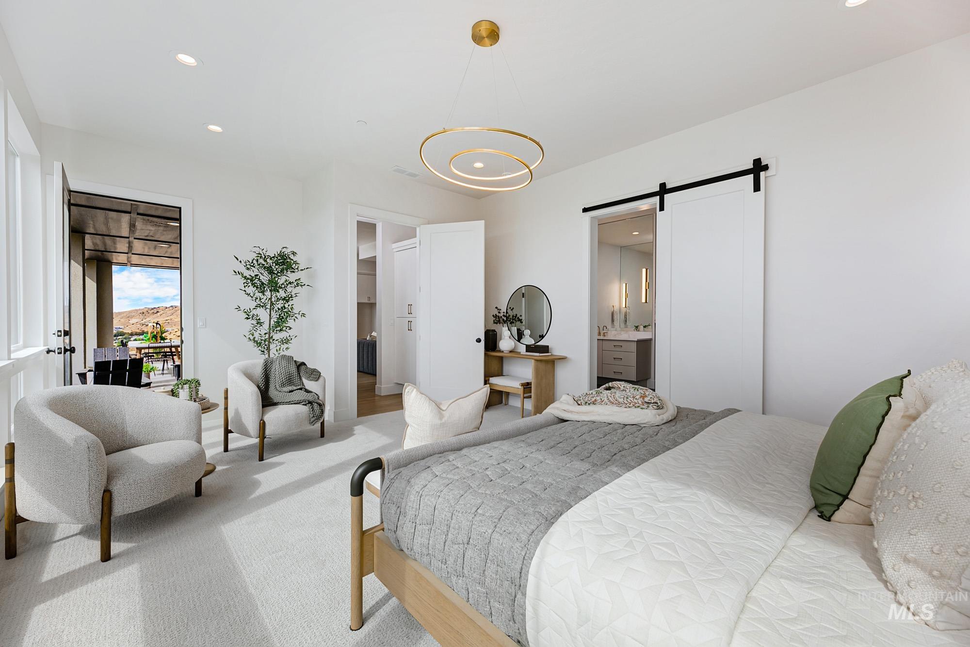 6177 East Prominence Drive Boise, ID 83716 - Photo 20 of 45 Bedroom with a barn door, recessed lighting, carpet, connected bathroom, and access to outside