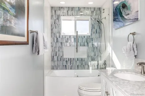 a bathroom with a granite countertop sink a toilet and bathtub