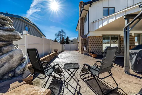 a view of a patio with table and chairs with wooden floor and fence