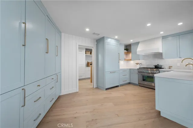 a kitchen with a sink white cabinets and stainless steel appliances