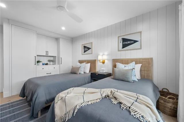 a bedroom with a bed potted plant on the dresser and mirror
