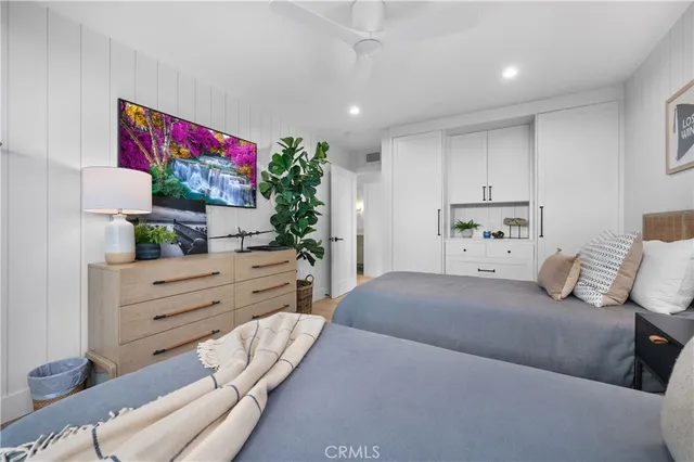 a bedroom with two beds and painting on the wall