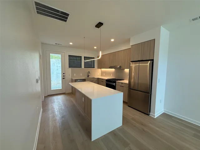 a view of kitchen with refrigerator microwave and wooden floor