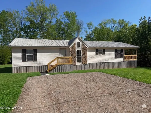 a view of a house with a yard and a garden