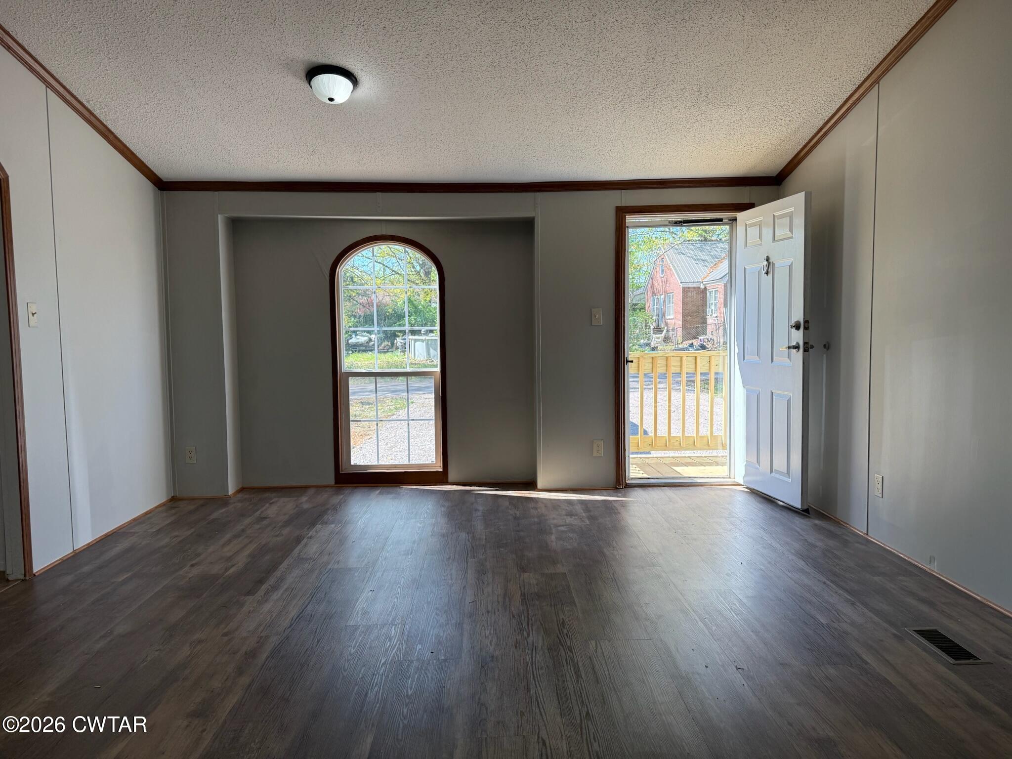 226 Massey Street Adamsville, TN 38310 - Photo 2 of 28 an empty room with wooden floor and a window