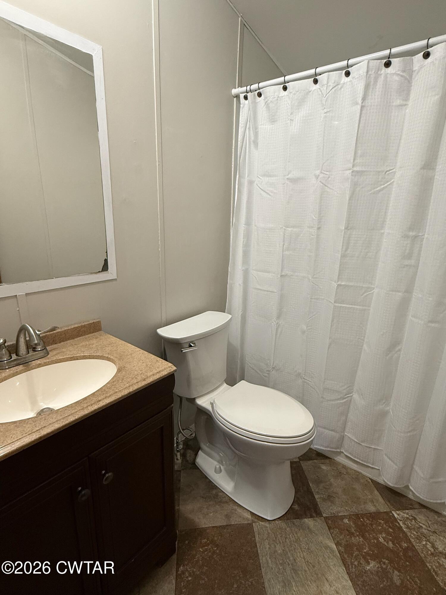 226 Massey Street Adamsville, TN 38310 - Photo 21 of 28 a bathroom with a granite countertop toilet sink and a mirror