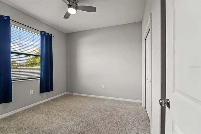 a view of a livingroom with a ceiling fan and window