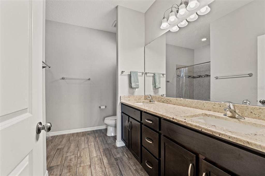 335 Old Windsor Way Spring Hill, FL 34609 - Photo 23 of 41 a spacious bathroom with a granite countertop sink a toilet and a mirror