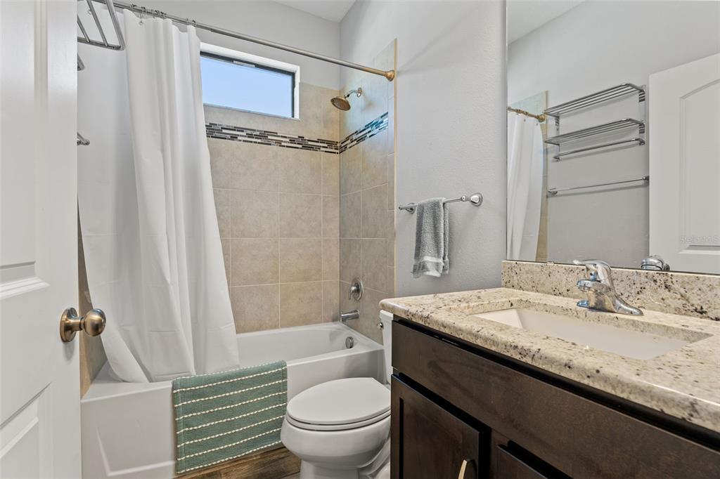335 Old Windsor Way Spring Hill, FL 34609 - Photo 29 of 41 a bathroom with a granite countertop sink toilet mirror and shower
