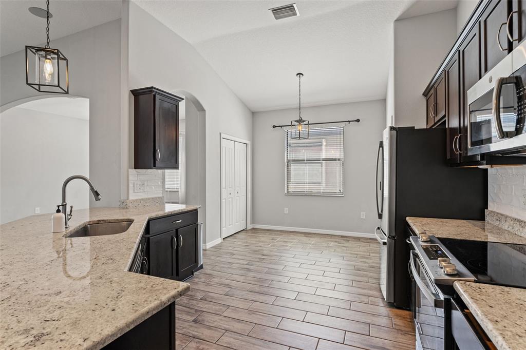 335 Old Windsor Way Spring Hill, FL 34609 - Photo 8 of 41 a kitchen with stainless steel appliances granite countertop a sink a stove and refrigerator