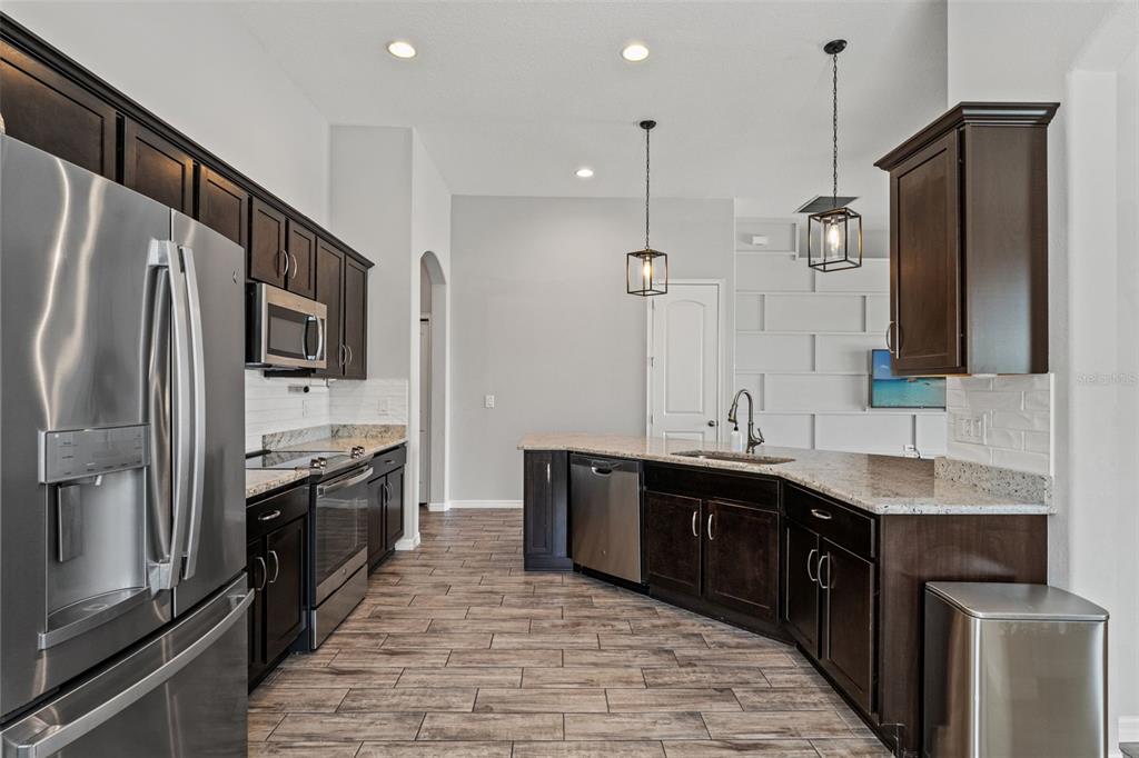 335 Old Windsor Way Spring Hill, FL 34609 - Photo 9 of 41 a large kitchen with stainless steel appliances a sink and a refrigerator