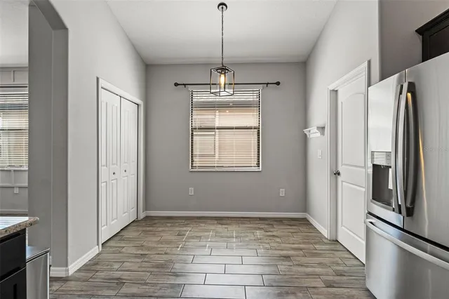 a view of a kitchen with a sink refrigerator and wooden floor