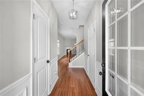 a view of a hallway with wooden floor and staircase