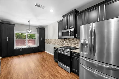 a kitchen with granite countertop stainless steel appliances and a refrigerator