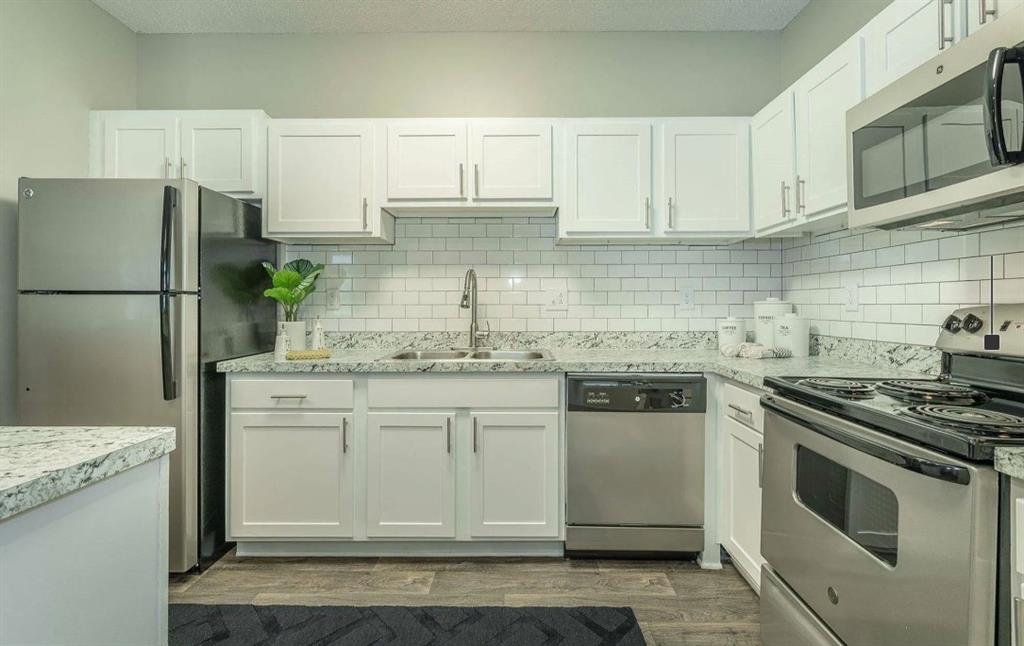3780 Towne Crossing, Unit 511E Kennesaw, GA 30144 - Photo 1 of 12 a kitchen with stainless steel appliances granite countertop a stove a refrigerator and a white cabinets
