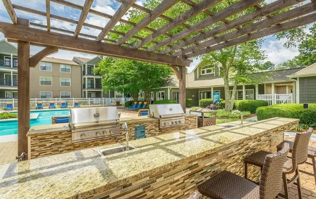 a view of a patio with table and chairs potted plants and large tree