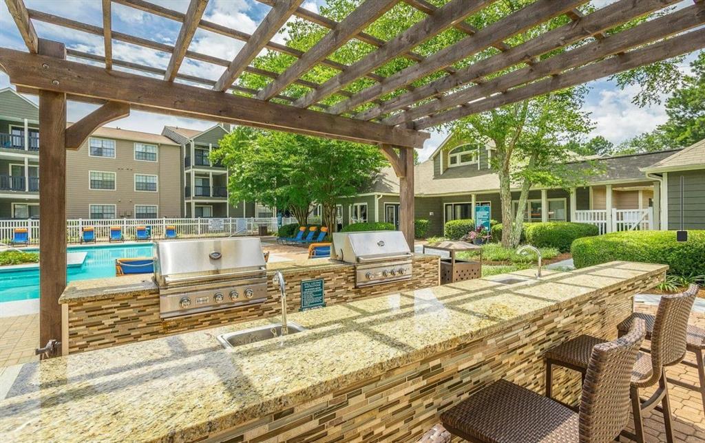 3780 Towne Crossing, Unit 511E Kennesaw, GA 30144 - Photo 11 of 12 a view of a patio with table and chairs potted plants and large tree