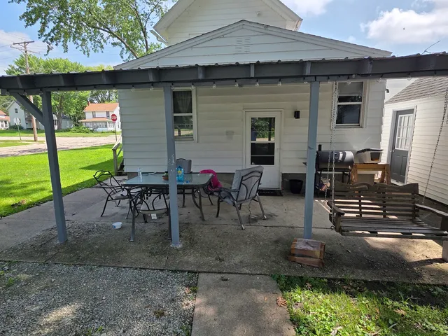 a view of a patio with table and chairs potted plants and a large tree
