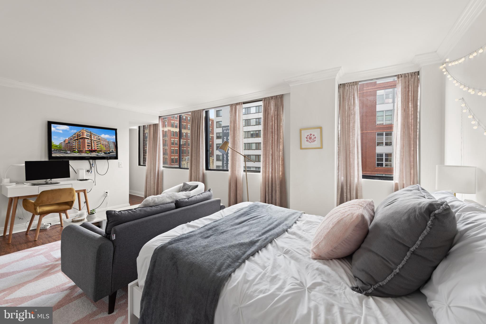 1245 13th Street Northwest, Unit 516 Washington, DC 20005 - Photo 12 of 25 a bedroom with a bed a couch and a flat screen tv