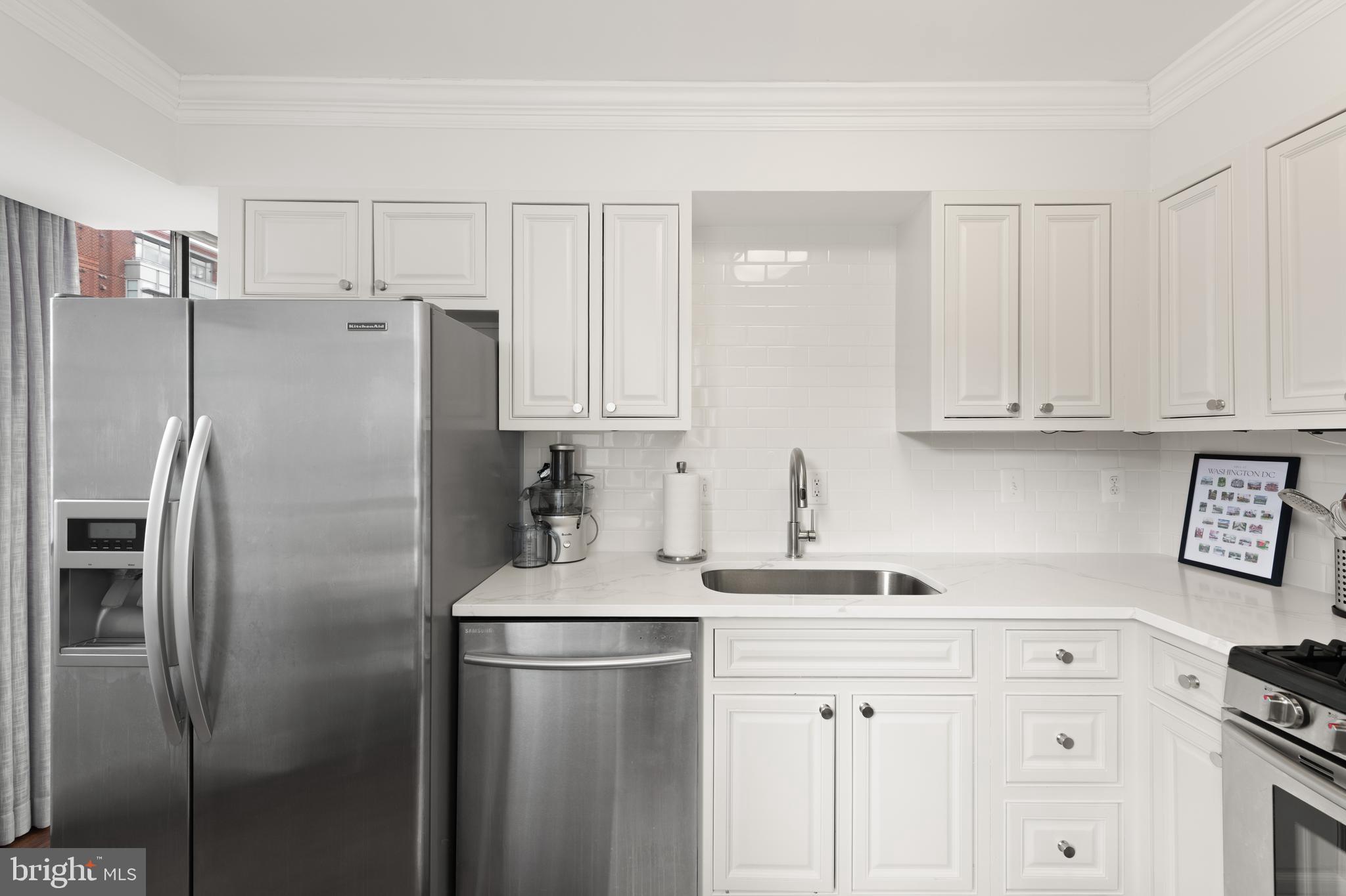 1245 13th Street Northwest, Unit 516 Washington, DC 20005 - Photo 15 of 25 a kitchen with stainless steel appliances a refrigerator sink and cabinets