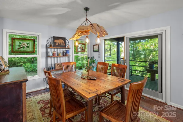a dining room with wooden floor furniture and a chandelier