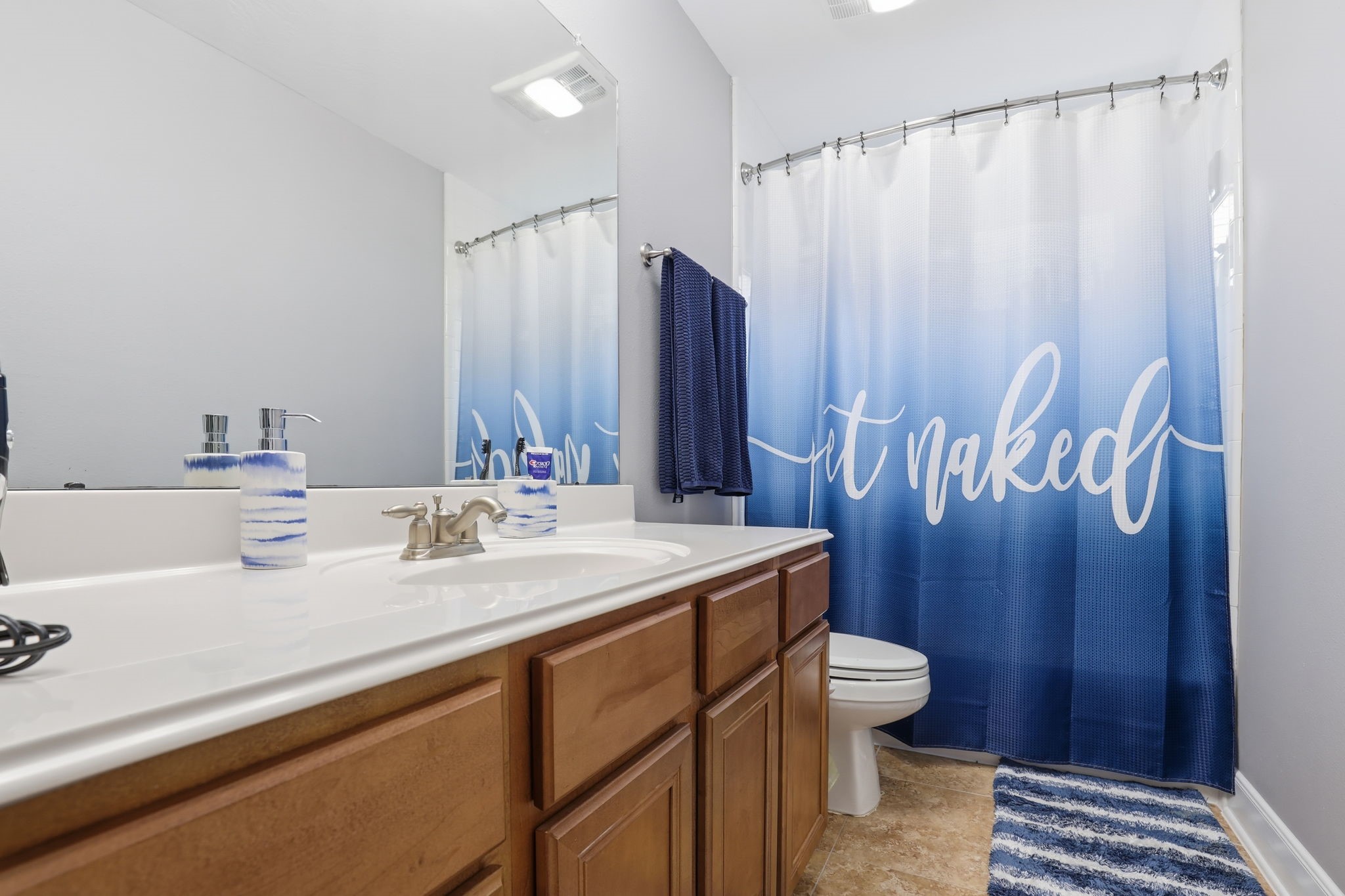 18014 Grotto Point Drive Cypress, TX 77429 - Photo 20 of 25 a bathroom with a sink a toilet and shower curtain