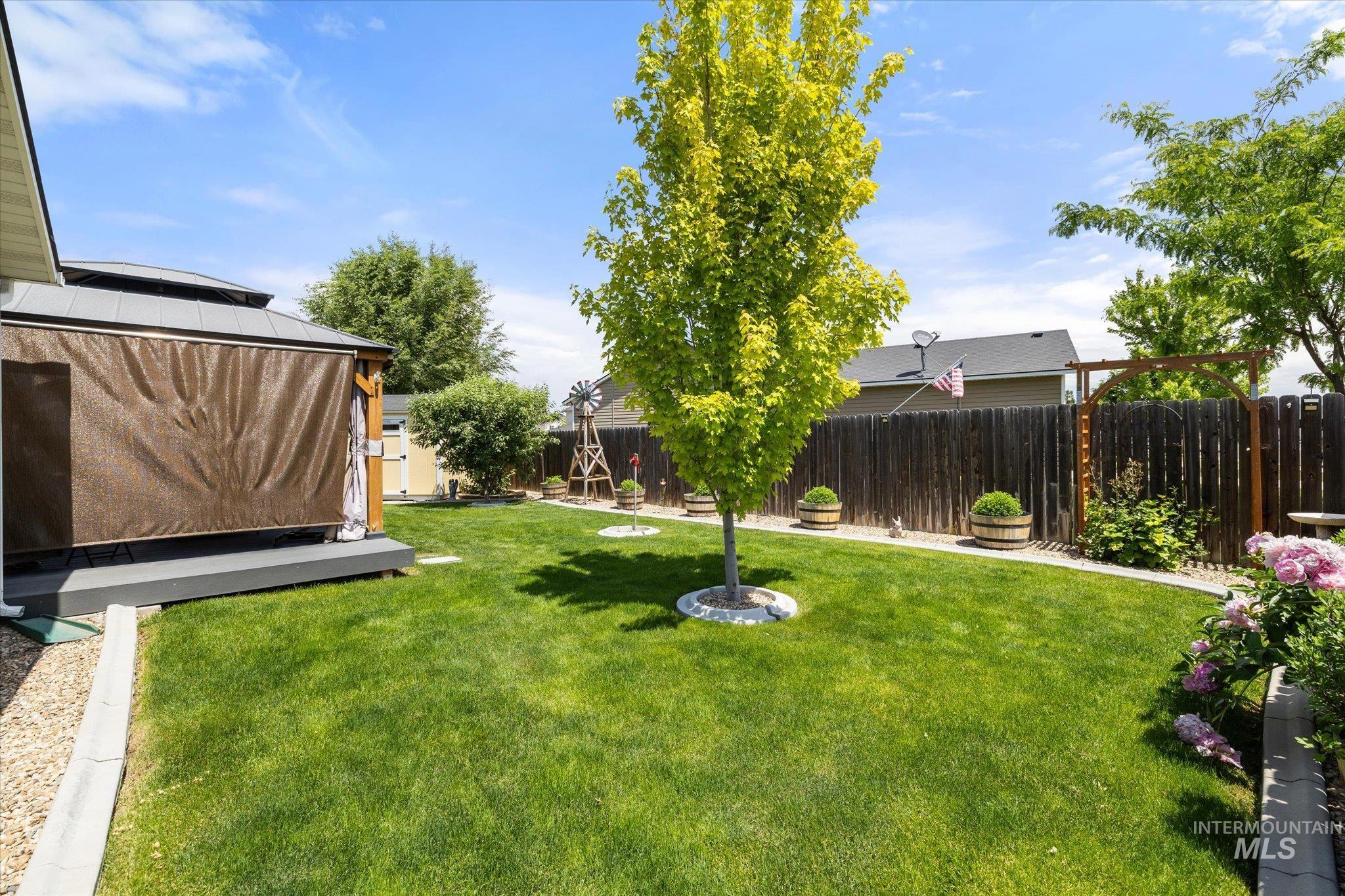 5401 Barkley Way Caldwell, ID 83607 - Photo 31 of 35 Manicured backyard featuring a lush lawn, privacy fencing, and mature landscaping