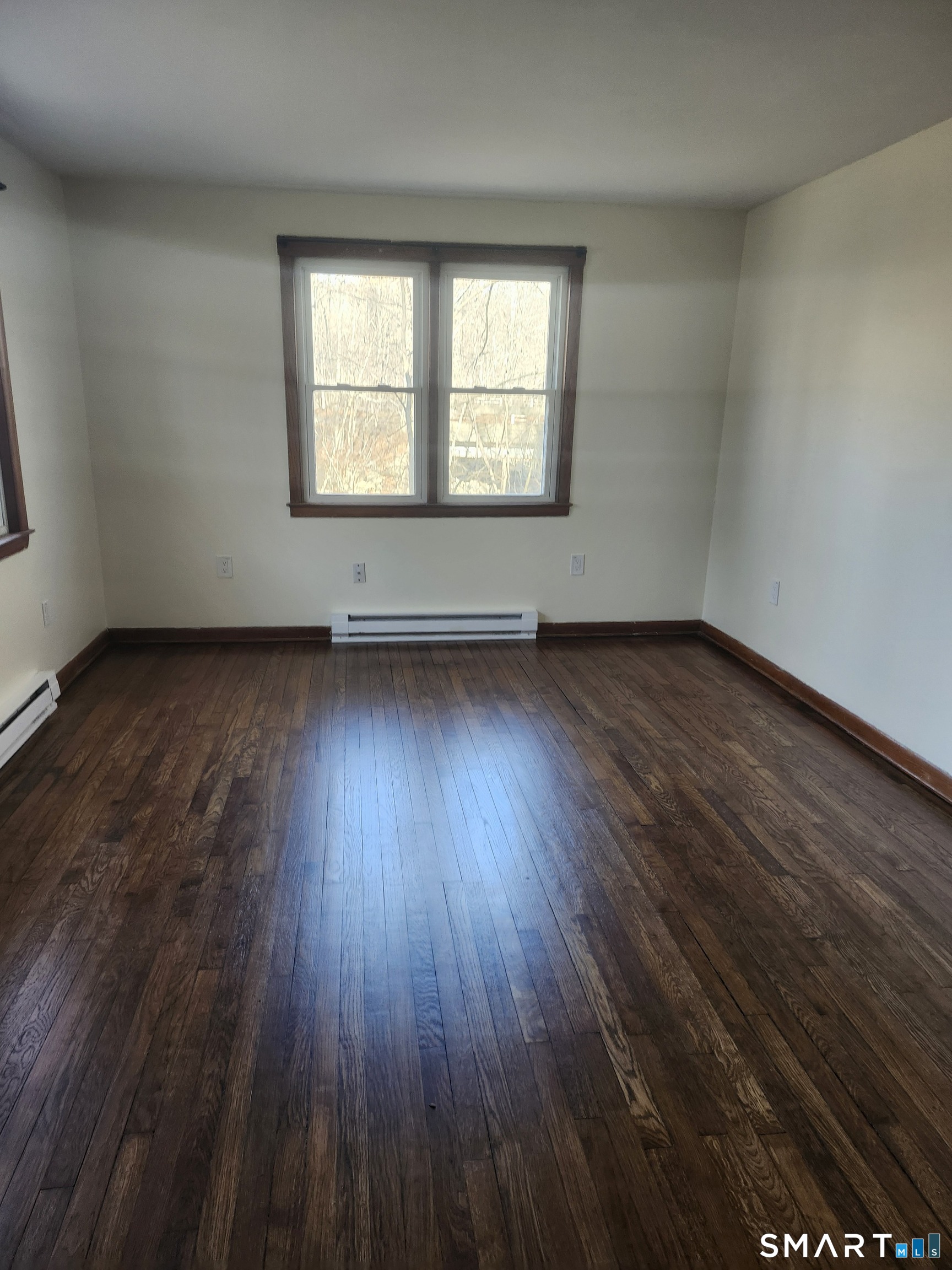 16 Polly Road, Unit A Lebanon, CT 06249 - Photo 5 of 9 an empty room with wooden floor and windows