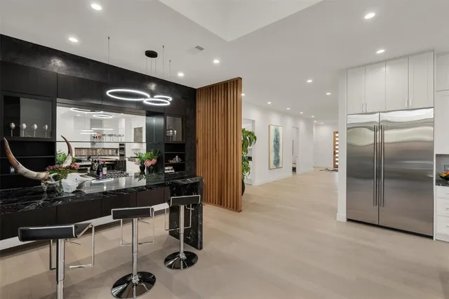 a kitchen with stainless steel appliances kitchen island granite countertop a refrigerator and cabinets