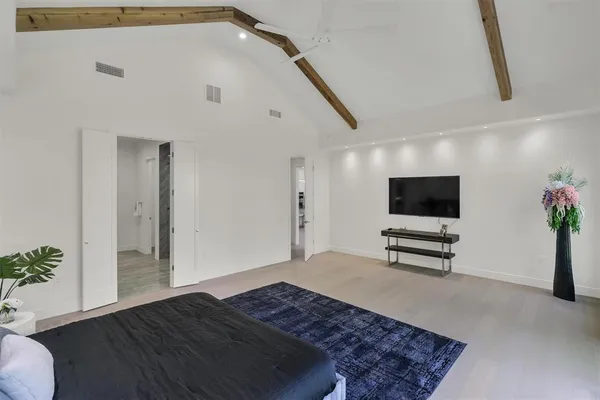 a bedroom with furniture and a flat screen tv