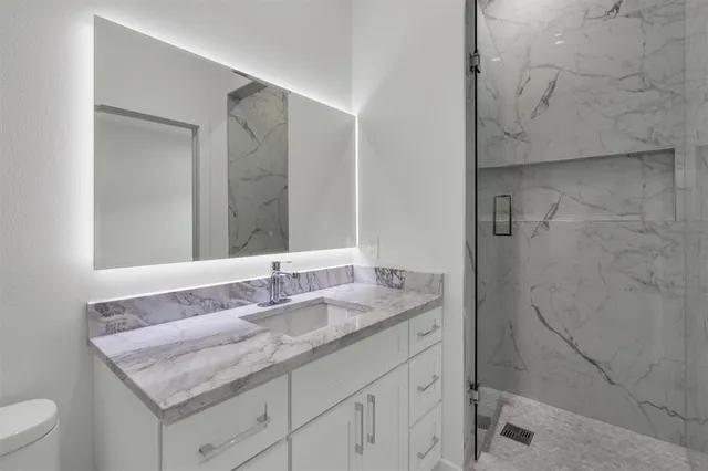 a bathroom with a granite countertop sink and a mirror