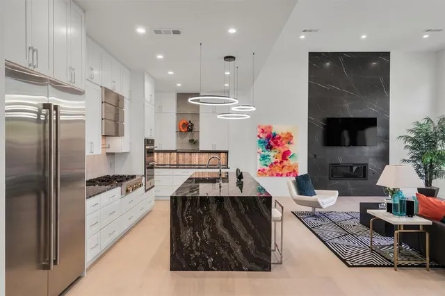 a kitchen with stainless steel appliances kitchen island granite countertop a refrigerator and a stove top oven